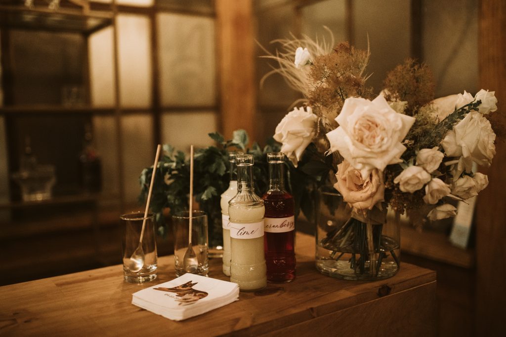 bar top details with florals and bottles filled with juice.
