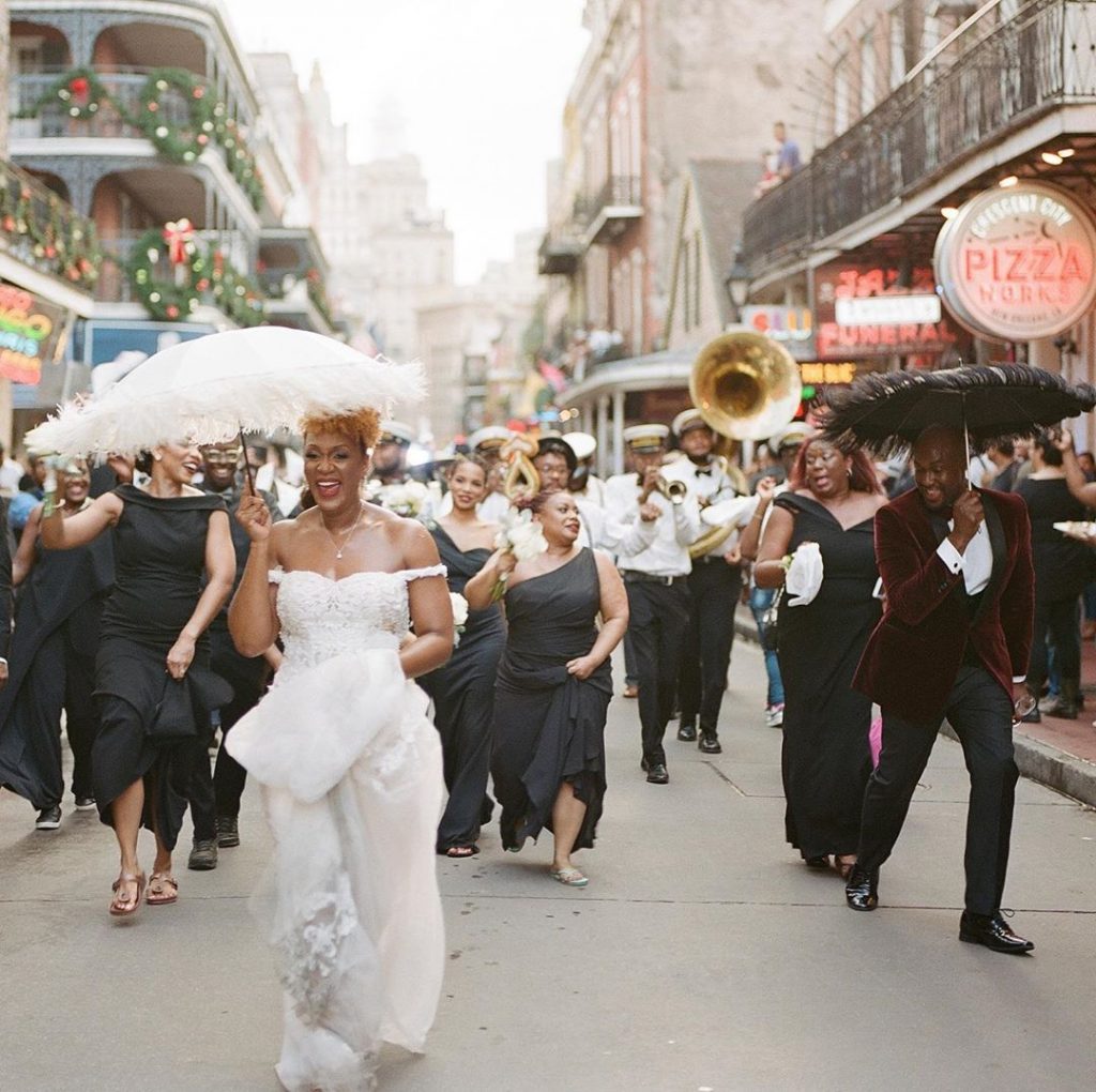 Wedding guest second lining down Bourbon Street in New Orleans