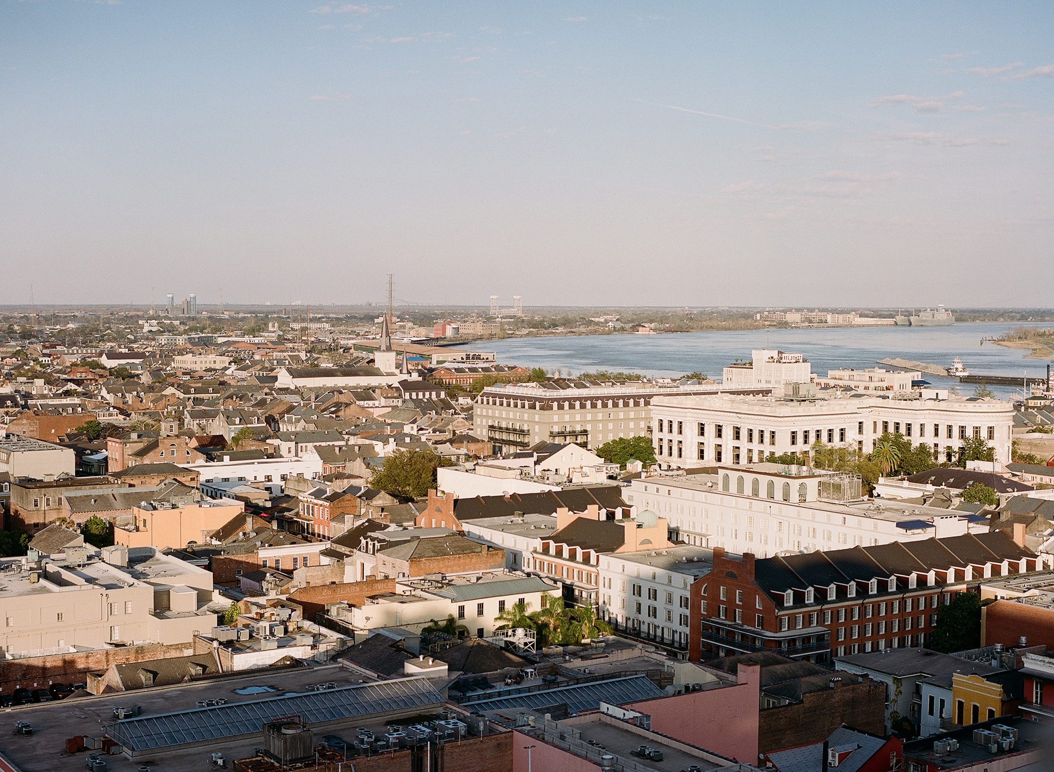 Aerial view of New Orleans showcasing historical buildings and the Mississippi River in the distance.