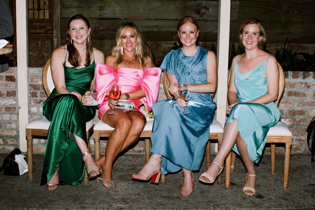 4 smiling ladies in colorful dresses